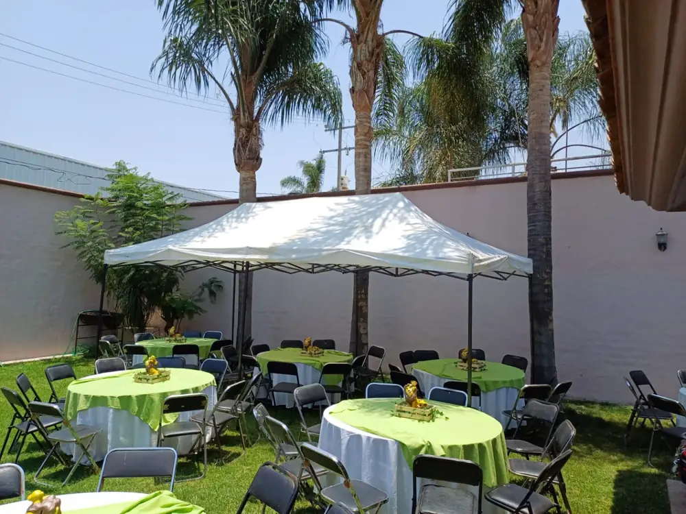 Mesas redondas con mantel verde para evento familiar