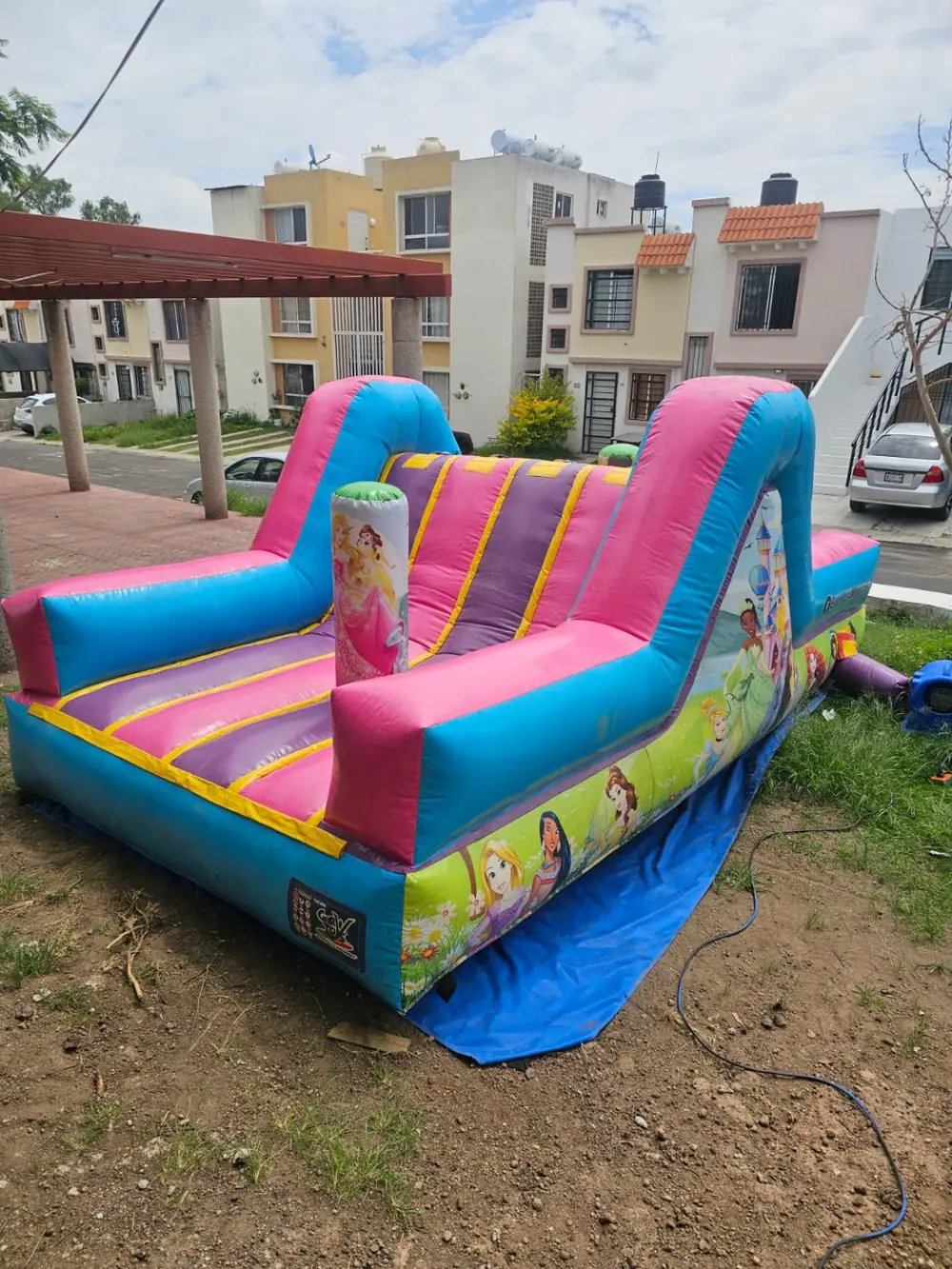 Mesas y sillas infantiles con inflable al fondo